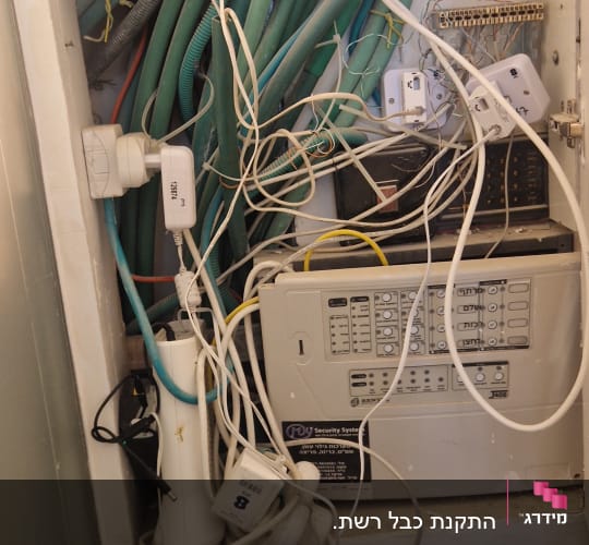 ארון תקשורת עם כבלים ומכשירים שונים